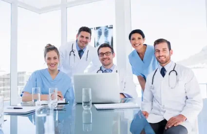 Portrait of a happy medical team using laptop together in the office